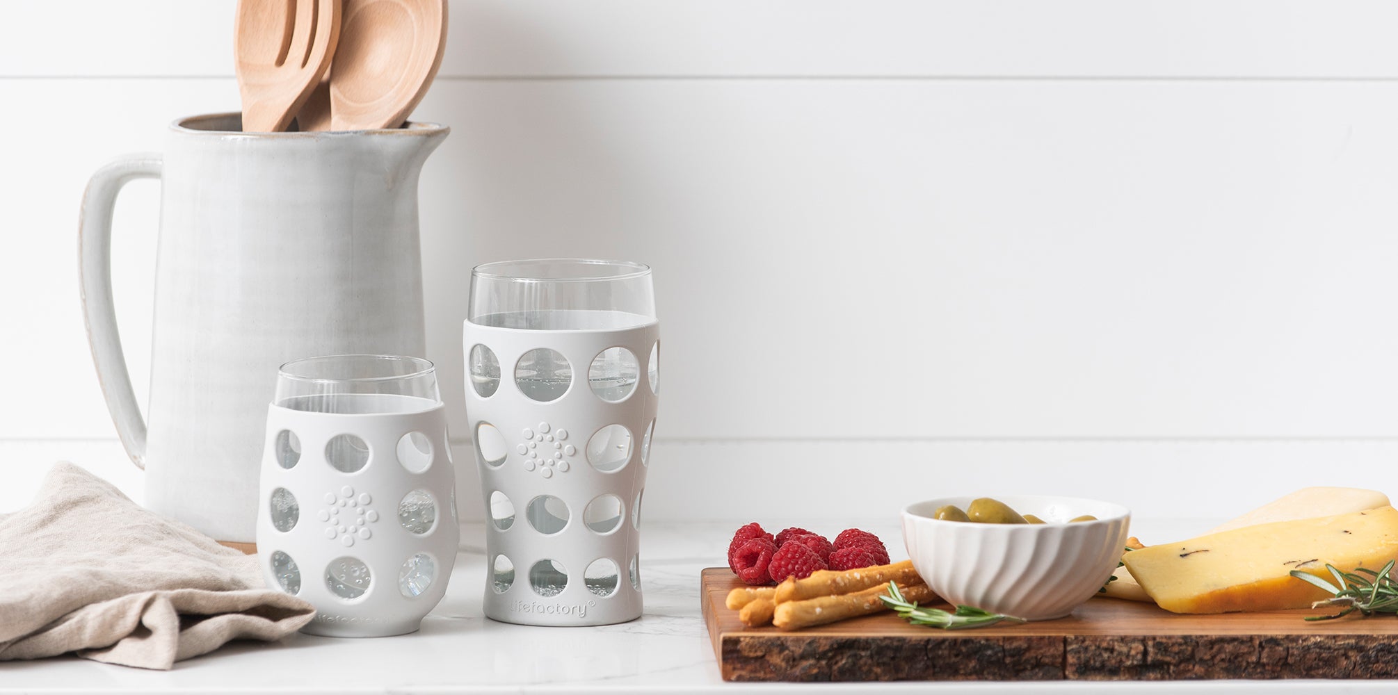 Lifefactory stemless wine glass and beer glass on a kitchen counter.