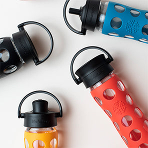 22oz Glass Water Bottles with assortment of caps.