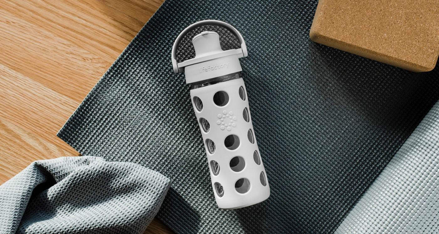 Glass water bottle with yoga equipment